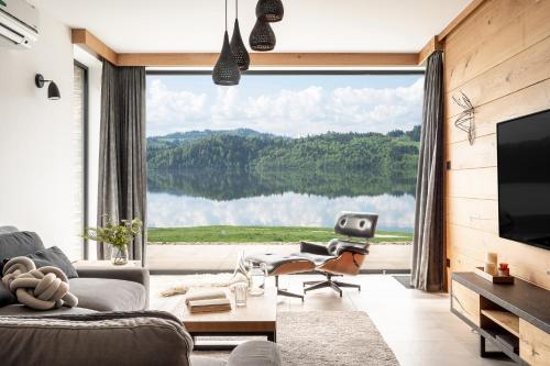 a living room with a large window with a view of a lake at Czorsztyn Prestige Apartamenty in Czorsztyn