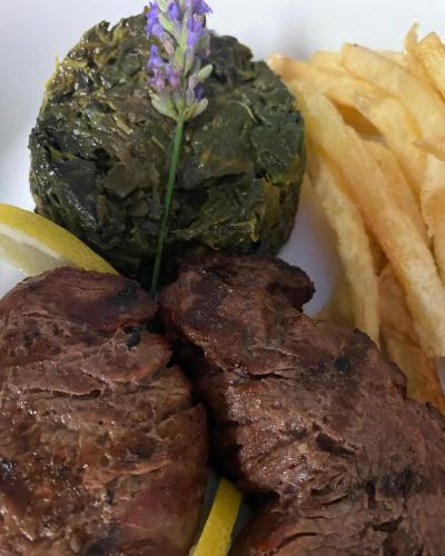a plate of steak and french fries with a flower on it at Varanda Do Alentejo in Marvão