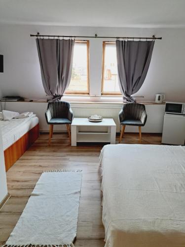 a bedroom with two beds and a table and two chairs at Piccola Italia Casa Racovita in Cluj-Napoca