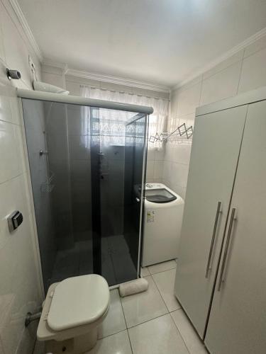 a bathroom with a toilet and a glass shower at Vista ao mar no Gonzaga in Santos