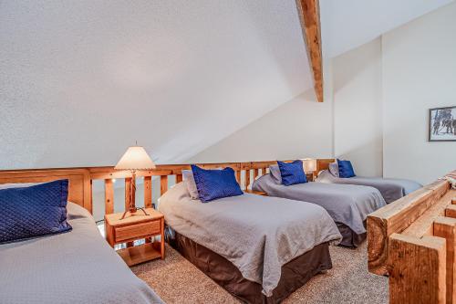 Habitación con 3 camas y almohadas azules. en Pine Ridge 05F, en Breckenridge