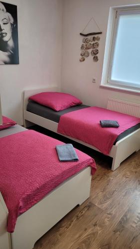 um quarto com duas camas com lençóis vermelhos e uma janela em Ferienwohnung in Mainz em Mainz