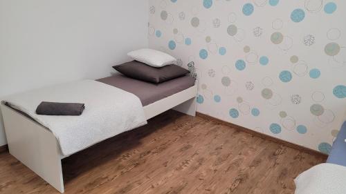 um pequeno quarto com uma cama e piso em madeira em Ferienwohnung in Mainz em Mainz