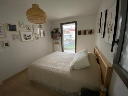 une chambre avec un grand lit avec une fenêtre dans l'établissement Appartement proche des pistes Serre Chevalier, à Briançon