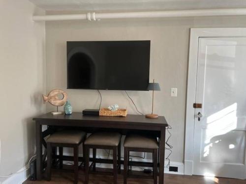 a dining room table with chairs and a television on a wall at Annapolis @Gate 1 steps to the Harbor Free parking in Annapolis
