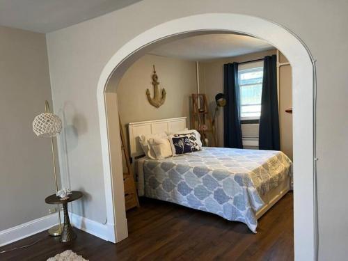 1 dormitorio con cama y puerta abovedada en Annapolis @Gate 1 steps to the Harbor Free parking, en Annapolis
