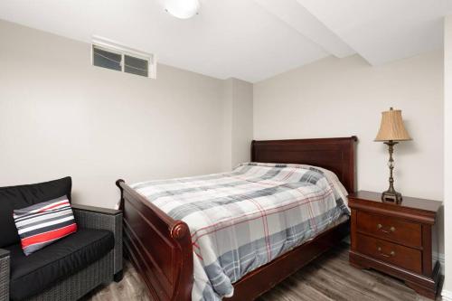 a bedroom with a bed and a chair in it at Walk-out Basement with Private Entrance in Brampton