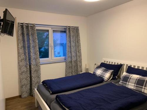 een slaapkamer met 2 bedden en een raam bij Ferienwohnung Gergert Nr6 in Löwenstein