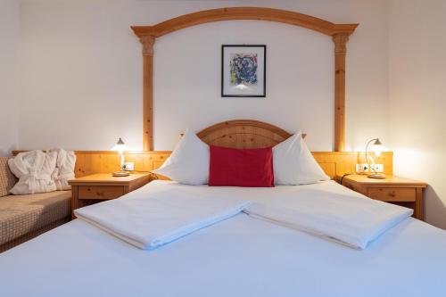 a bedroom with a bed with a red pillow on it at Cristallo B&B in Castelrotto