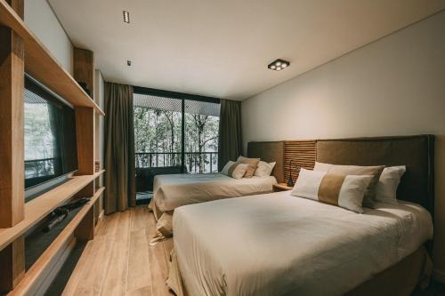 a bedroom with two beds and a large window at Get Hotel Molvento, AKEN Soul Collection in Villa General Belgrano