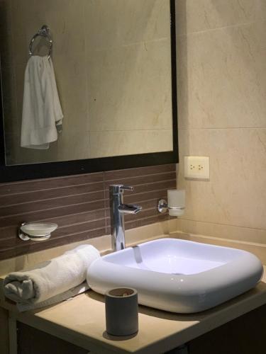 ein weißes Waschbecken im Bad mit Spiegel in der Unterkunft Isla Privada al interior de Colombia en Prado Tolima in Prado