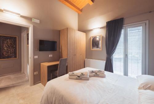 a bedroom with a bed and a desk and a television at Agriturismo Querceto in Frazione Mocaiana
