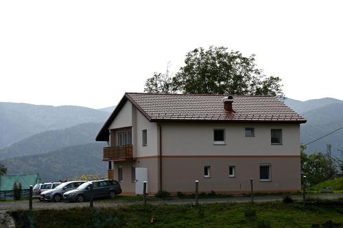 duży biały dom z samochodami zaparkowanymi na parkingu w obiekcie Domačija KOHOVO w mieście Sveti Lovrenc