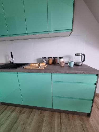 a kitchen with blue cabinets and a counter top at Dom na Ubocy in Groń