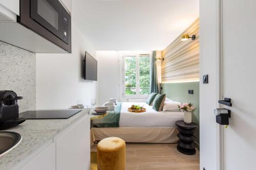 niewielka sypialnia z łóżkiem i oknem w obiekcie Résidence Saint Charles - Parc des Expositions w Paryżu