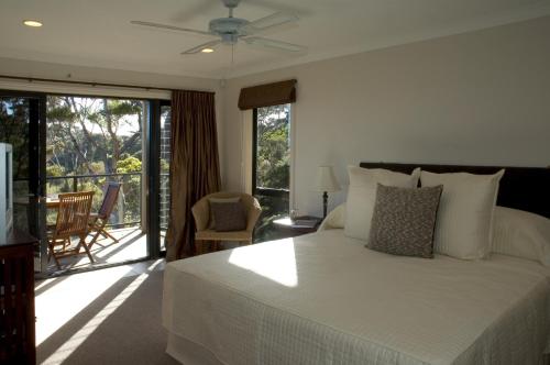 a bedroom with a bed and a balcony with a view at The Sanctuary at Bay of Islands in Opua