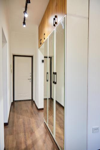 an empty hallway with glass doors and wooden floors at Апартаменты Центр Медеуский Район in Almaty