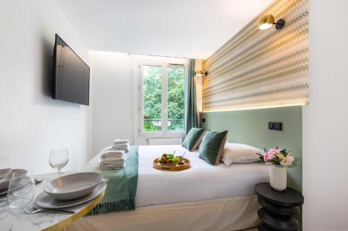 sypialnia z dużym białym łóżkiem i oknem w obiekcie Résidence Saint Charles - Parc des Expositions w Paryżu
