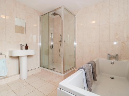 a bathroom with a shower and a tub and a sink at Morgan House in Bridgwater