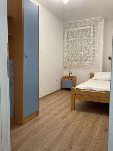 um quarto branco com uma cama e uma janela em Apartman Palac em Grude