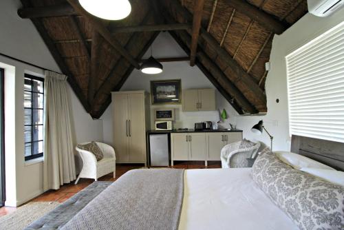 a bedroom with a bed and a kitchen at Mountain View Swellendam in Swellendam