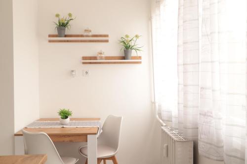 comedor con mesa, sillas y ventana en Zoé Apartman Debrecen Nagyerdő, en Debrecen