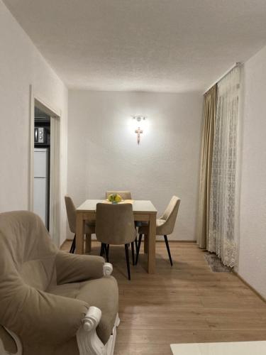 uma sala de estar com uma mesa de jantar e cadeiras em Apartman Palac em Grude