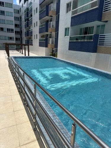 a large swimming pool in front of a building at Apartamento beira mar in João Pessoa