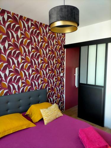 - une chambre avec un lit violet et un mur coloré dans l'établissement Maison du petit p(a)in, à Cucq
