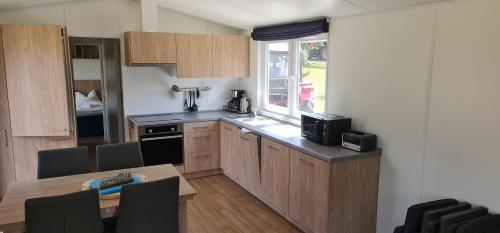 a kitchen with wooden cabinets and a table and a window at Haus Chios in Birgland