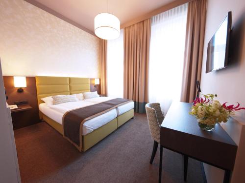 Un pat sau paturi într-o cameră la Drei Kronen Hotel Wien City
