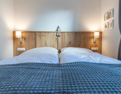 a bedroom with a large bed with a wooden headboard at Villa Elisabeth in Strobl