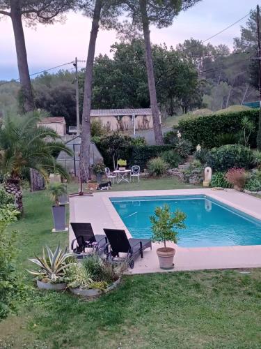 - une piscine dans une cour avec 2 chaises et une table dans l'établissement Le mas de Phil, à Peymeinade
