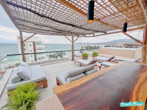 a patio with a table and chairs and the ocean at Arenka - 2BR w Private Pool & Sunset Rooftop in Bucerías