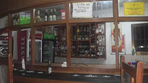 a bar with a lot of bottles of alcohol at Makambo-te Makuti Cottage in Arusha