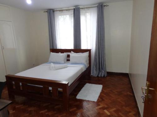 a bedroom with a bed and a window with curtains at Amani guest house in Nairobi