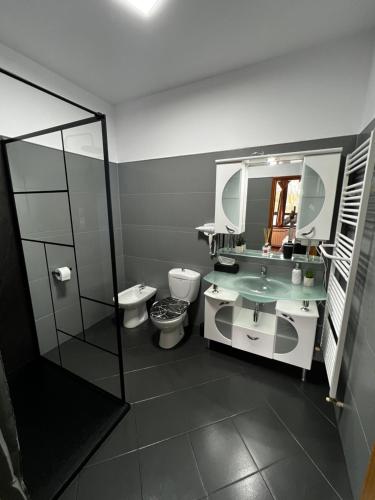 Un baño con dos inodoros, un lavabo y un espejo. en Infinity Villa, en Buşteni