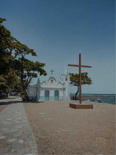 a church on the beach with a cross in front at AL MAR SUÍTES in Praia do Forte