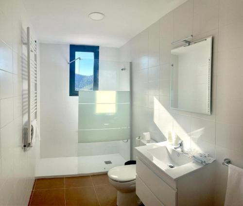 a white bathroom with a toilet and a sink at Corazón de Javalambre 