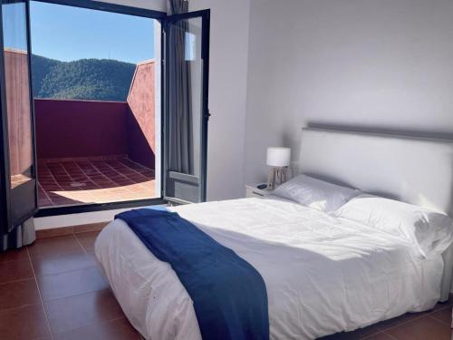 ein Schlafzimmer mit einem Bett und einem großen Fenster in der Unterkunft Corazón de Javalambre 