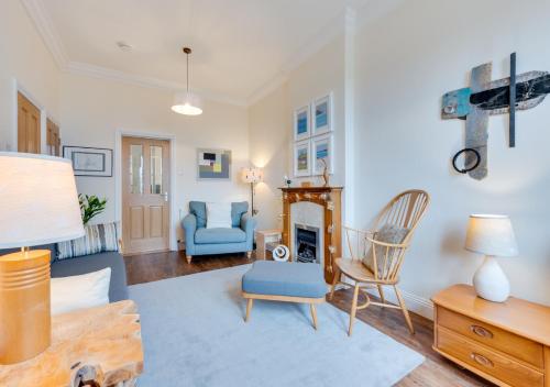 een woonkamer met een blauwe bank en een open haard bij Herbert's Place in Swanage