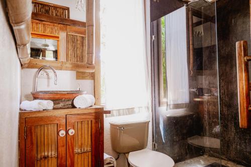 uma casa de banho com um WC, um lavatório e um chuveiro em Griss Lodge & Villas em Santa Teresa