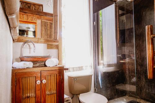 a bathroom with a toilet and a sink and a shower at Griss Lodge & Villas in Santa Teresa Beach