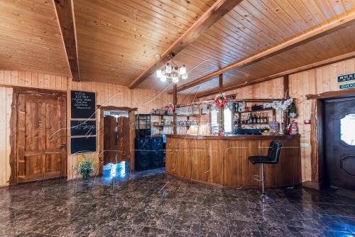 a bar in a room with wooden walls at ПІД МАГУРОЮ in Pilipets