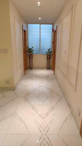 a large room with a white marble floor and windows at The Grand Uddhav- a boutique hotel in Udaipur