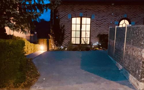 una entrada de entrada por la noche frente a un edificio de ladrillo en Au coeur du 11, en Beyne-Heusay