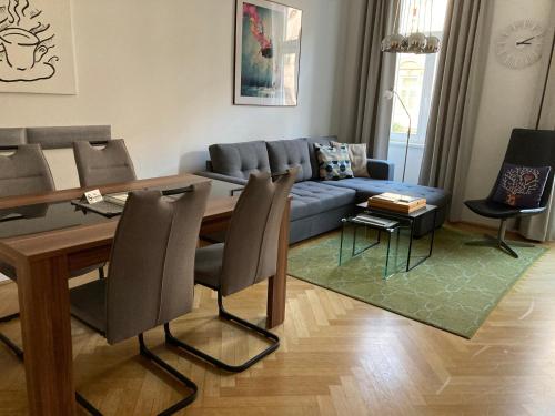 a living room with a blue couch and a table at Apartment Vienna Living in Vienna