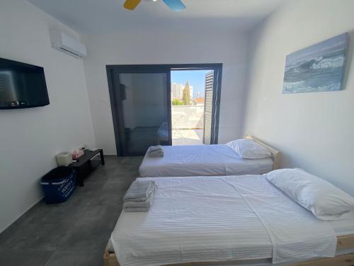 a bedroom with two beds and a television in it at Green Bay Area Apartment in Protaras