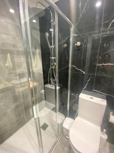 a bathroom with a toilet and a glass shower at Green Bay Area Apartment in Protaras