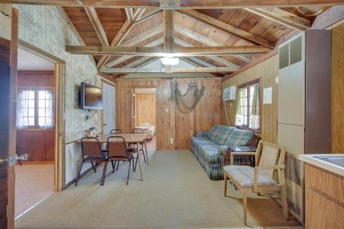 a living room with a table and a couch at Stone Lake Cabin with Private Deck and Fire Pit! in Northwoods Beach